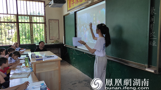 （图为志愿者在教小朋友唱《红星闪闪》 刘雅璐 摄）